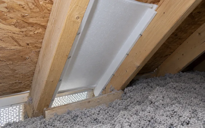 Déflecteur blanc maintenant un passage d’air entre le soffite et le pontage